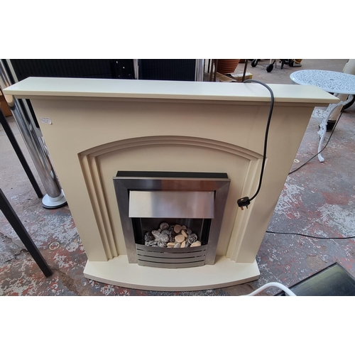 821 - A brushed stainless steel electric fire with mantel style surround