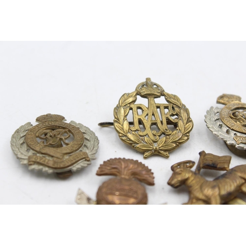 1185 - Ten military cap badges to include The Lancashire Fusiliers, The Devonshire Regiment etc.