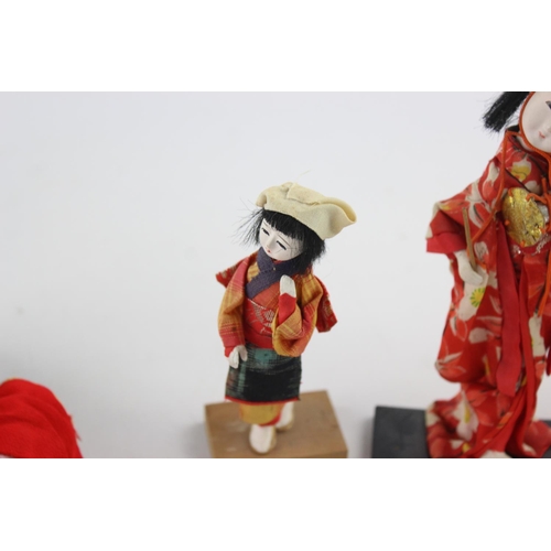 353 - Four Oriental collector's dolls