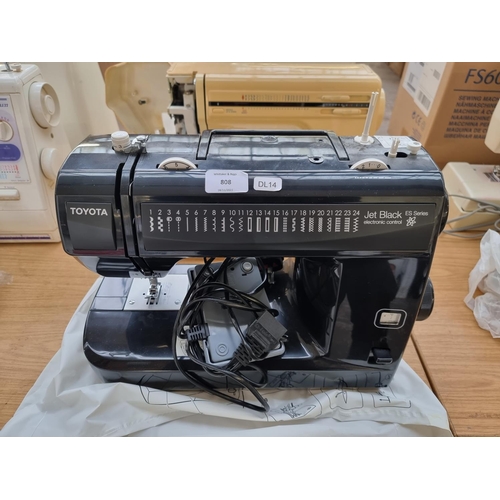 808 - A Toyota Jet Black ES Series electric sewing machine with foot pedal and cover