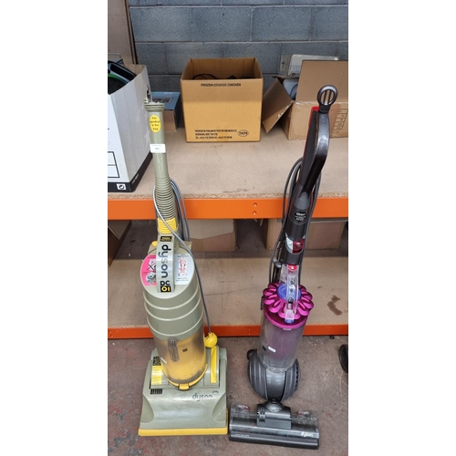 831 - Two Dyson upright bagless vacuum cleaners, one DC01 and one DC40