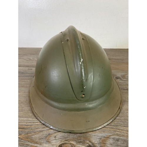 512 - A WWII French Adrian helmet with machine gun corps badge to front