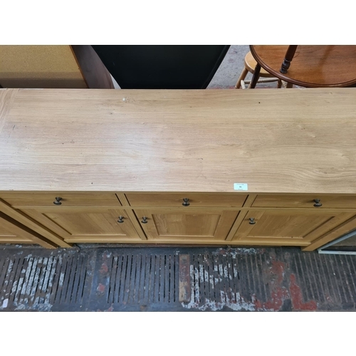 86 - A modern oak effect sideboard with three drawers and three cupboard doors - approx. 77.5cm high x 13... 