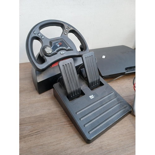 734 - A collection of gaming items to include Mad Catz steering wheel with pedals, Thrustmaster steering w... 