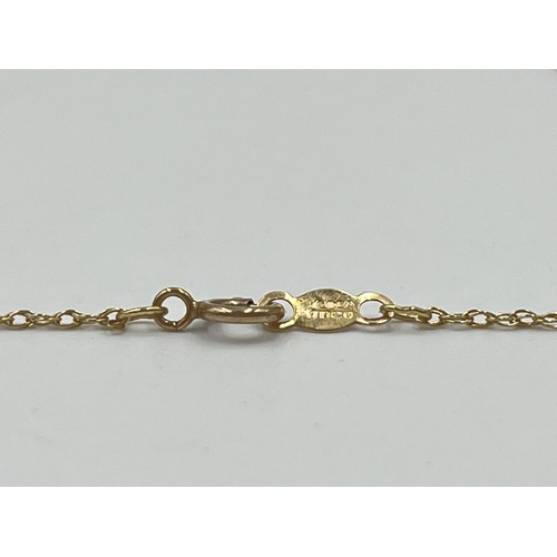 1086 - A hallmarked 14ct gold chain necklace with seven charms - approx. gross weight 2.3 grams