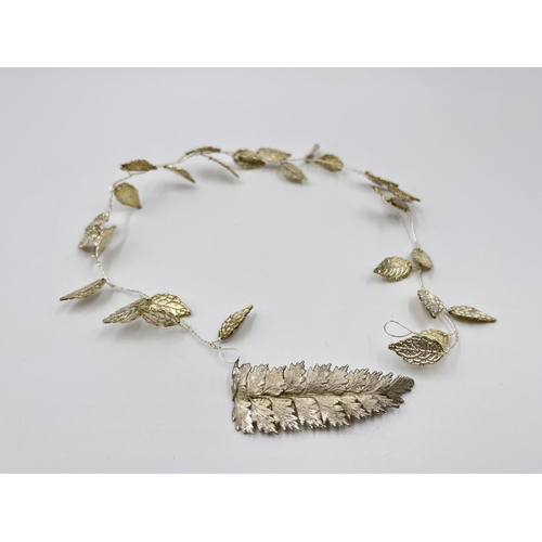 1096 - Two items, one white metal Grecian leaf hair vine and one white metal leaf brooch