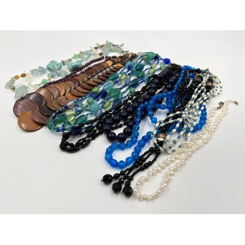 1103 - A collection of beaded necklaces to include foiled glass, carved teak etc.