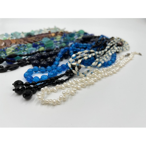 1103 - A collection of beaded necklaces to include foiled glass, carved teak etc.