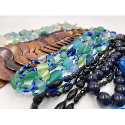 1103 - A collection of beaded necklaces to include foiled glass, carved teak etc.