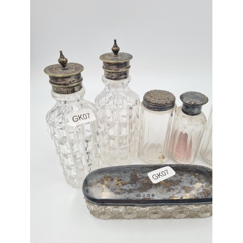 1265 - Seven antique glass bottles and vanity jars, five with hallmarked sterling silver tops and two with ... 