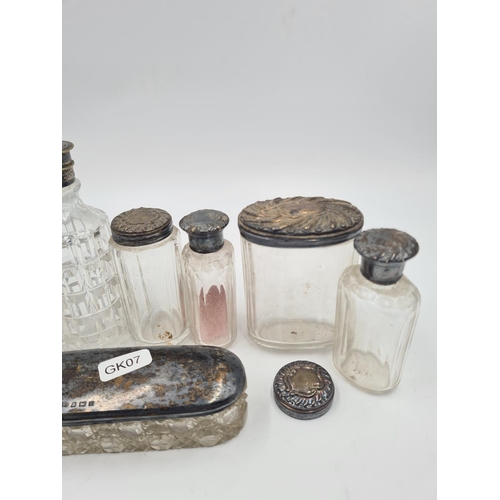 1265 - Seven antique glass bottles and vanity jars, five with hallmarked sterling silver tops and two with ... 