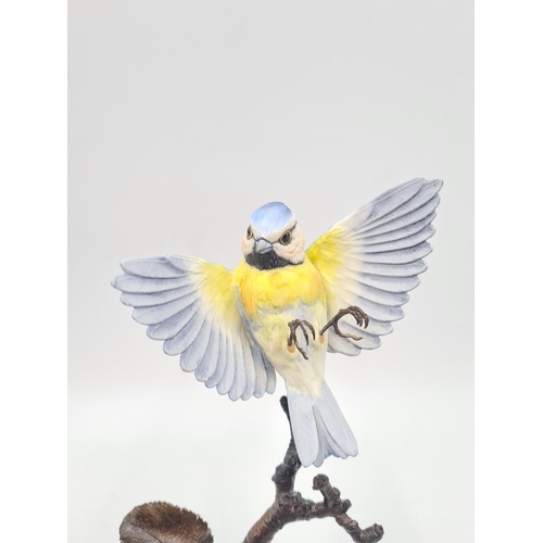 244 - Four ceramic figurines to include Albany Worcester blue tit on bronze branch - approx. 20cm high, Ro... 