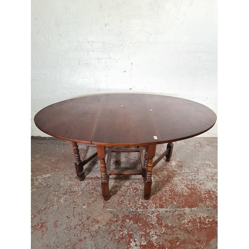 37 - An oak drop leaf gate leg oval dining table