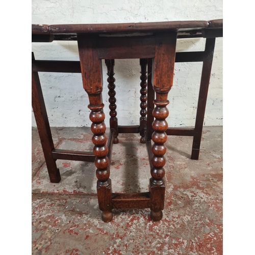 11 - An 18th century oak drop leaf gate leg dining table with bobbin turned supports - approx. 74cm high ... 