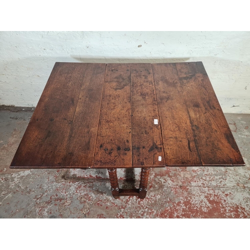 11 - An 18th century oak drop leaf gate leg dining table with bobbin turned supports - approx. 74cm high ... 