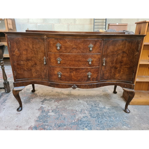 13 - A Regency style burr walnut serpentine sideboard with three drawers, two cupboard doors and cabriole... 