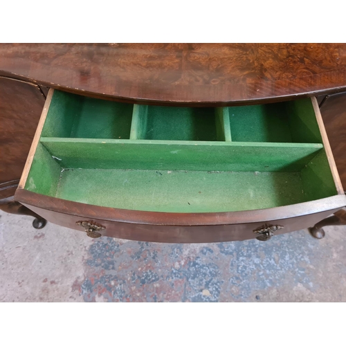 13 - A Regency style burr walnut serpentine sideboard with three drawers, two cupboard doors and cabriole... 