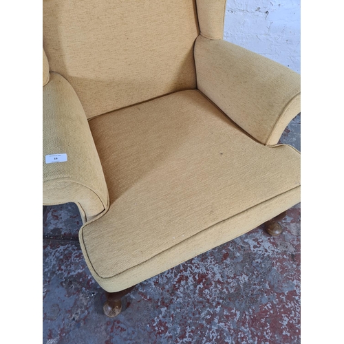 16 - A Victorian style yellow upholstered wing back armchair on cabriole supports - approx. 97cm high x 7... 