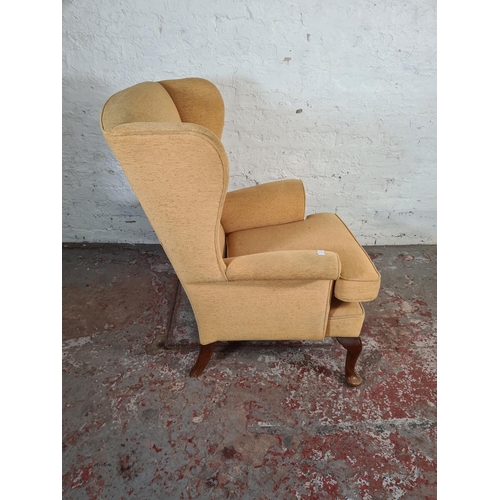 16 - A Victorian style yellow upholstered wing back armchair on cabriole supports - approx. 97cm high x 7... 