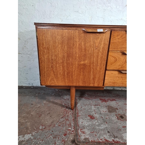 17 - A mid 20th century teak sideboard with three central drawers and two outer cupboard doors - approx. ... 