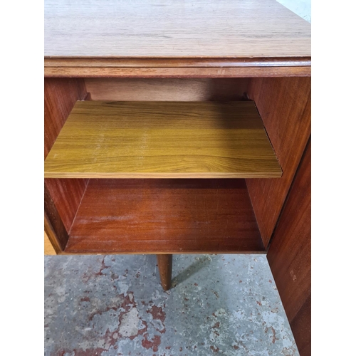 17 - A mid 20th century teak sideboard with three central drawers and two outer cupboard doors - approx. ... 