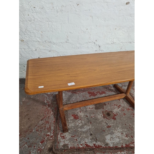 24 - A mid 20th century teak effect rectangular coffee table - approx. 40cm high x 46cm wide x 107cm long