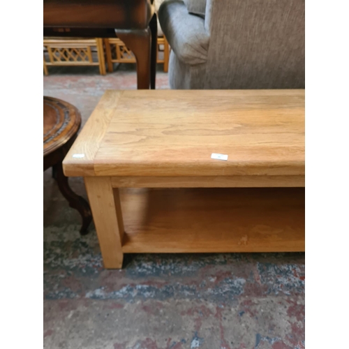 25 - A modern solid oak rectangular two tier coffee table - approx. 45cm high x 54cm wide x 110cm long