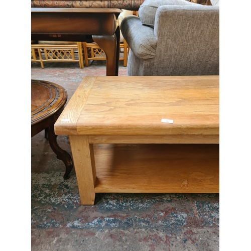 25 - A modern solid oak rectangular two tier coffee table - approx. 45cm high x 54cm wide x 110cm long