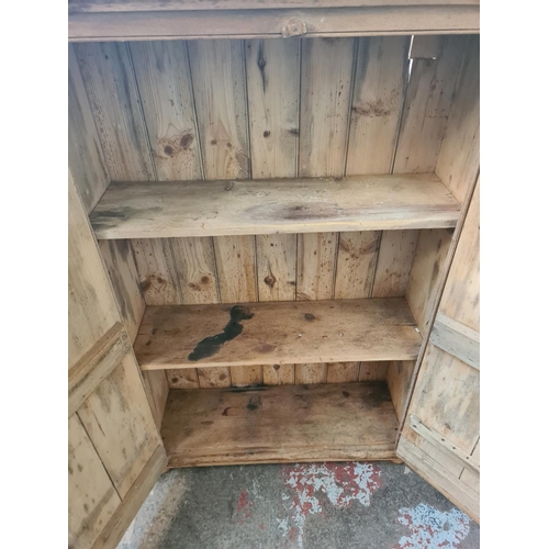 29 - A 19th century style solid pine two door cabinet with three internal shelves - approx. 144cm high x ... 