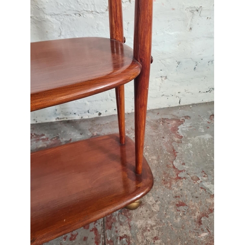 38 - A mid 20th century Ercol elm and beech three tier trolley on castors - approx. 71cm high x 90cm wide... 