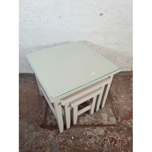 40 - A modern grey painted nest of three tables - approx. 56cm high x 60cm square