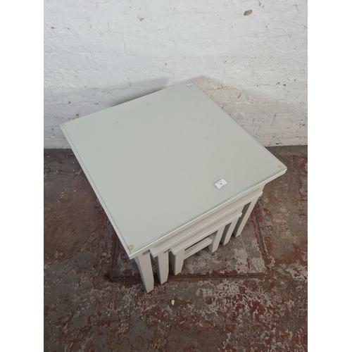 40 - A modern grey painted nest of three tables - approx. 56cm high x 60cm square