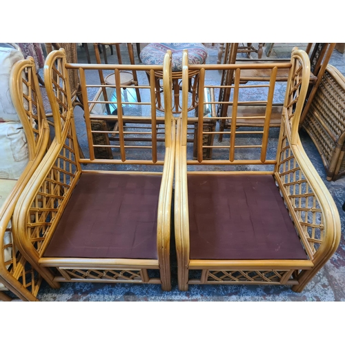 53 - A bamboo and cane three piece conservatory suite comprising two armchairs and three seater sofa