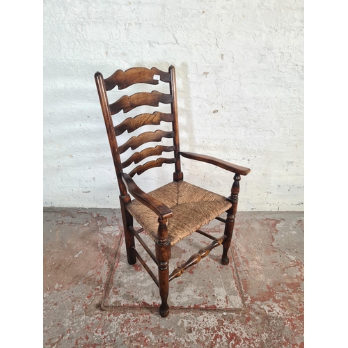 54A - A 19th century style beech and elm rushed seated carver dining chair