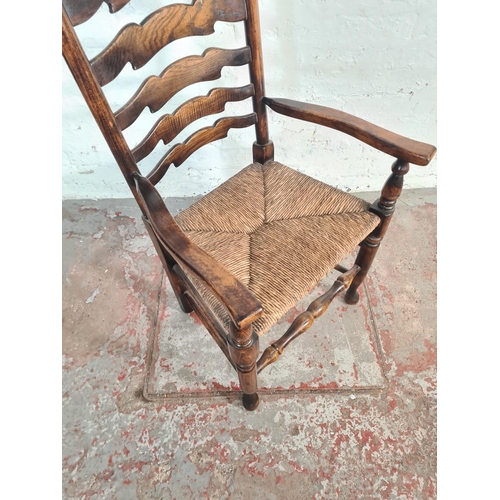 54A - A 19th century style beech and elm rushed seated carver dining chair