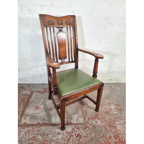 55 - Four oak dining chairs, one Arts & Crafts carver with green leatherette upholstery and three 1930s