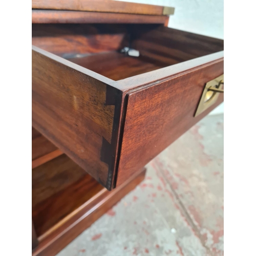 60 - A mahogany and brass campaign style two drawer bedside cabinet