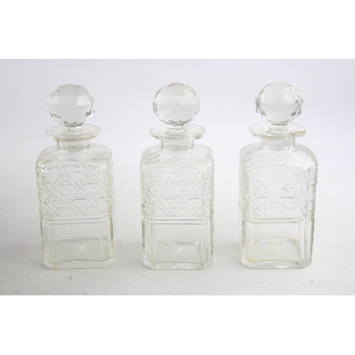 493 - An early 20th century oak and silver plated tantalus with three cut glass decanters