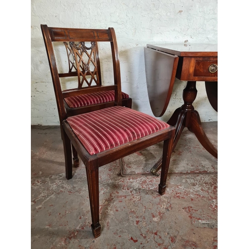 116 - A Regency style mahogany drop leaf pedestal dining table with two drawers, brass lion paw supports a... 