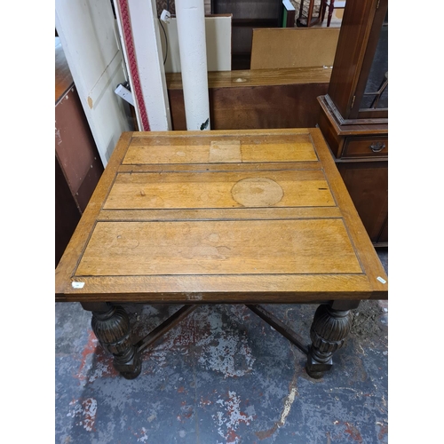 136 - A 1930s solid oak drawer leaf dining table with baluster supports - approx. 76cm high x 107cm wide x... 