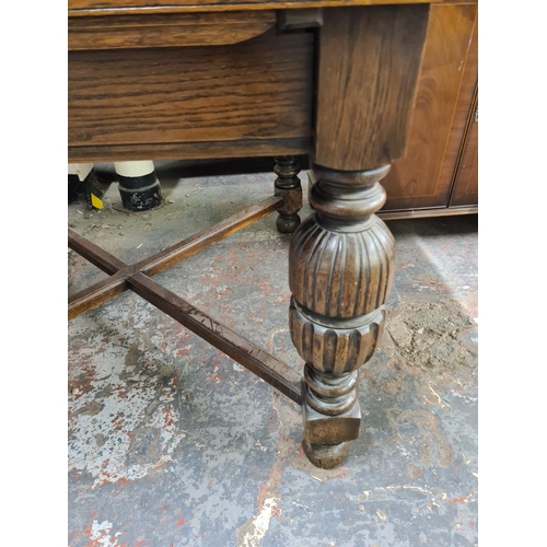 136 - A 1930s solid oak drawer leaf dining table with baluster supports - approx. 76cm high x 107cm wide x... 