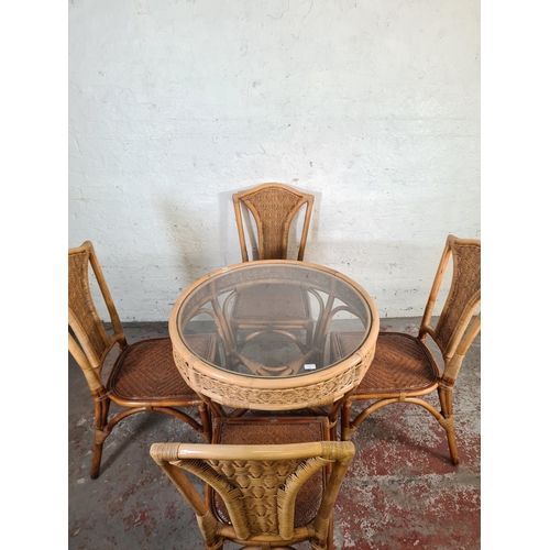 81 - A bamboo and wicker circular dining table with glass insert and four dining chairs - approx. 75cm hi... 