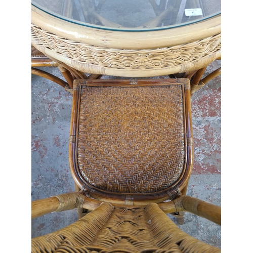 81 - A bamboo and wicker circular dining table with glass insert and four dining chairs - approx. 75cm hi... 