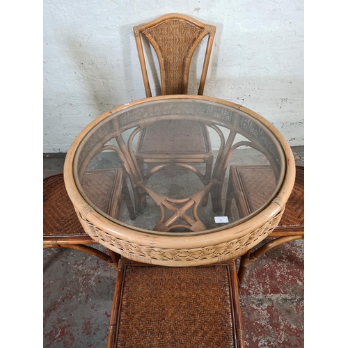 81 - A bamboo and wicker circular dining table with glass insert and four dining chairs - approx. 75cm hi... 