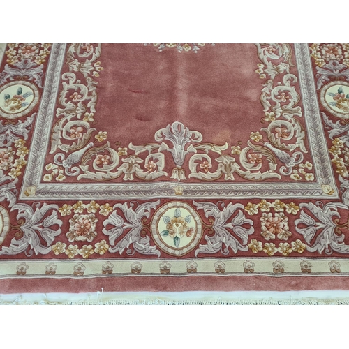 143F - A pink and cream floral patterned tasselled rug - approx. 310cm long x 215cm wide