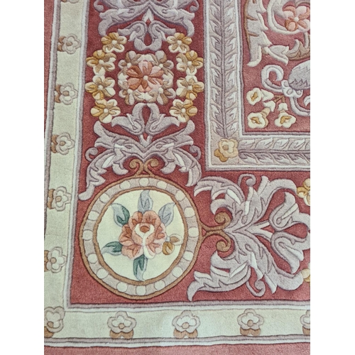 143F - A pink and cream floral patterned tasselled rug - approx. 310cm long x 215cm wide