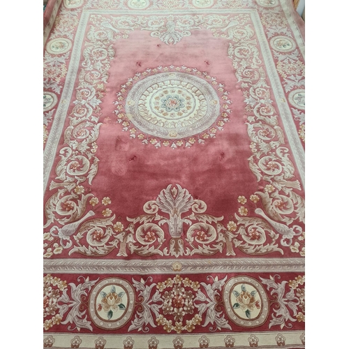 143G - A pink and cream floral patterned tasselled rug - approx. 375cm long x 280cm wide