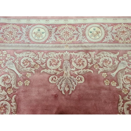 143G - A pink and cream floral patterned tasselled rug - approx. 375cm long x 280cm wide