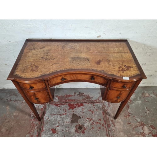 143I - A Regency style mahogany and tan leather serpentine writing desk with five drawers and tapering supp... 