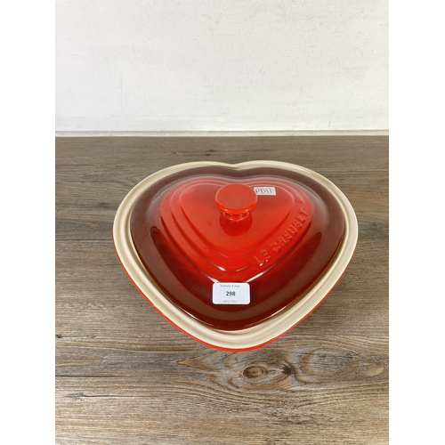 298 - A Le Creuset red glazed stoneware heart shaped 2.4L casserole dish and lid